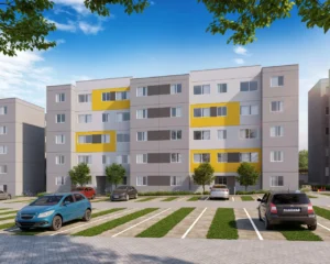 Edifício residencial moderno com fachada cinza e amarela, estacionamento com carros e árvores em frente, sob um céu azul.